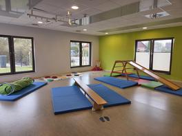 Der Bewegungsraum in der Kita Jungfernbusch mit mit Rutsche, einer Bank zum Balancieren und einem "Krabbeltunnel"